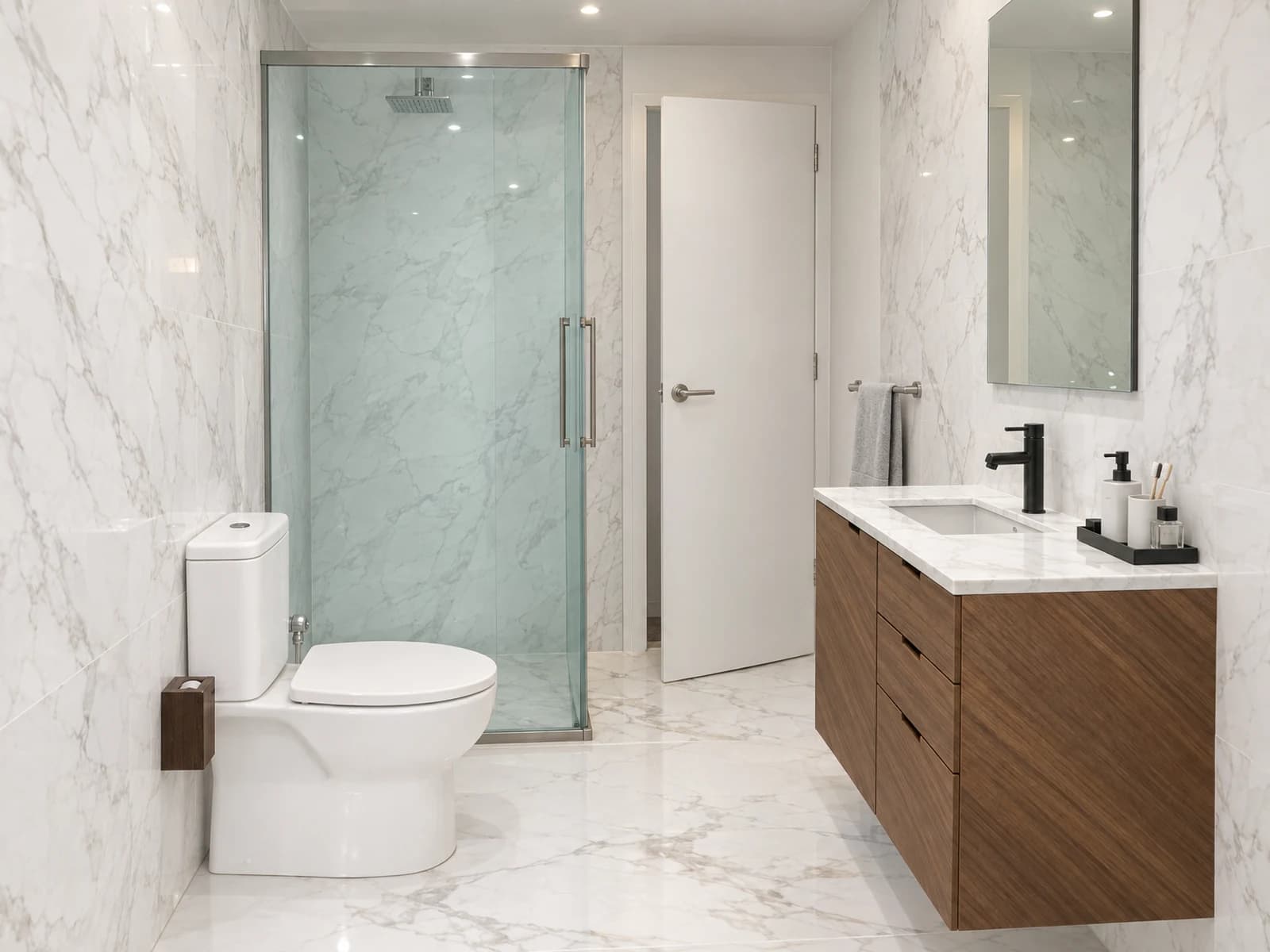 The same bathroom rendered as built: sliding glass shower with back-to-back handles and a white door ajar straight ahead, toilet on the left, walnut vanity with a black mixer and tall mirror on the right