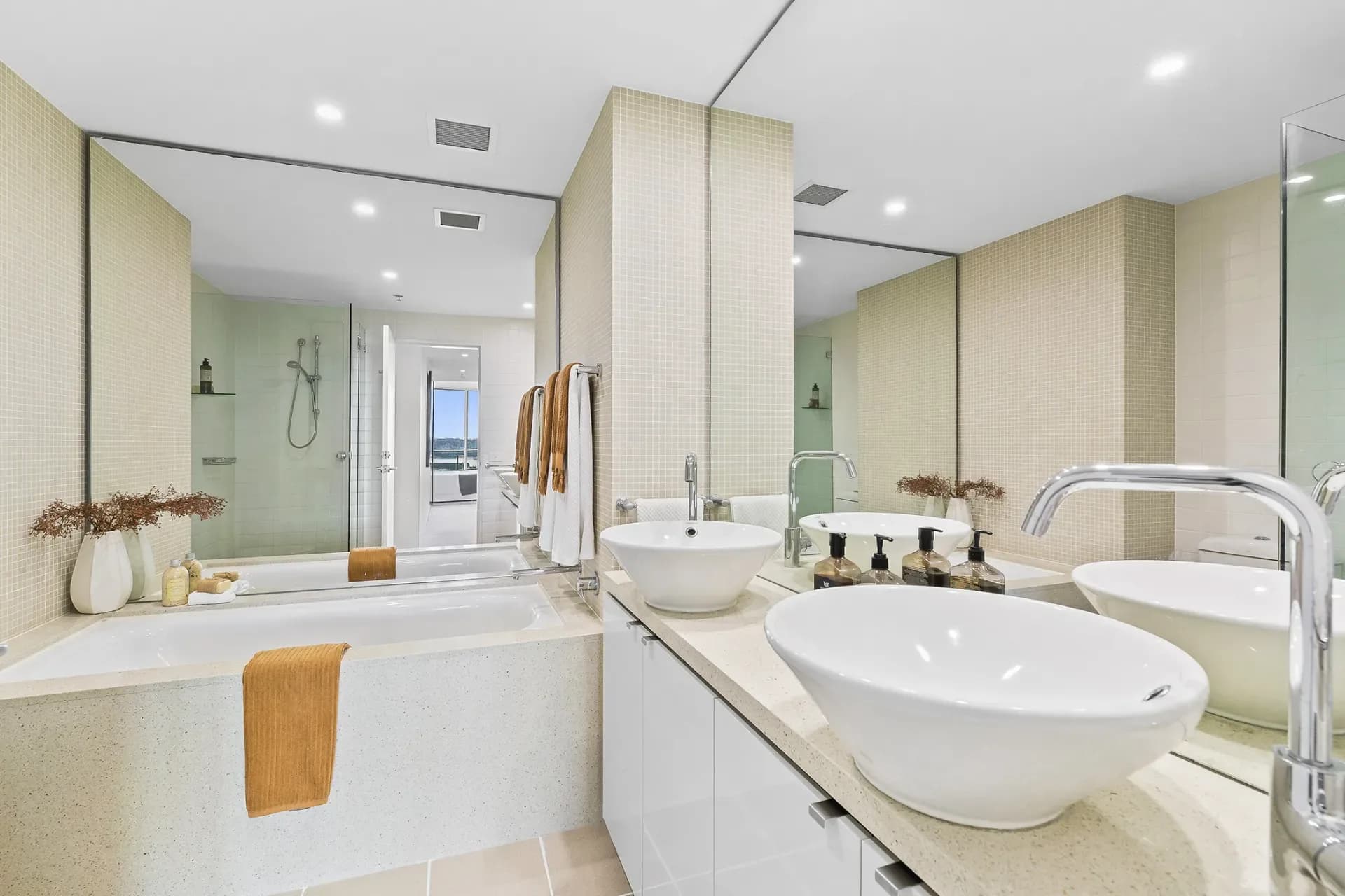 Original cream tiled bathroom with twin white vessel basins and an inset bath