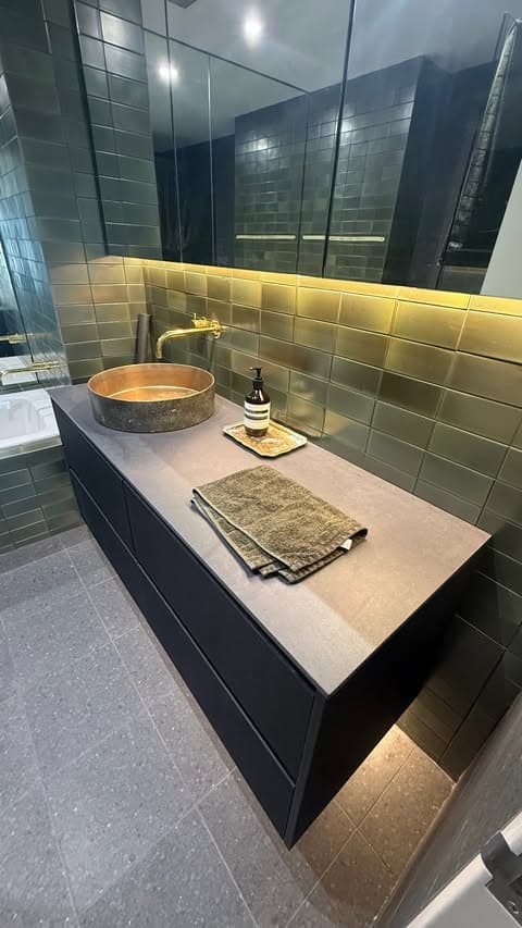 Finished Surry Hills bathroom with olive green subway tiles, a bronze vessel basin and a black floating vanity