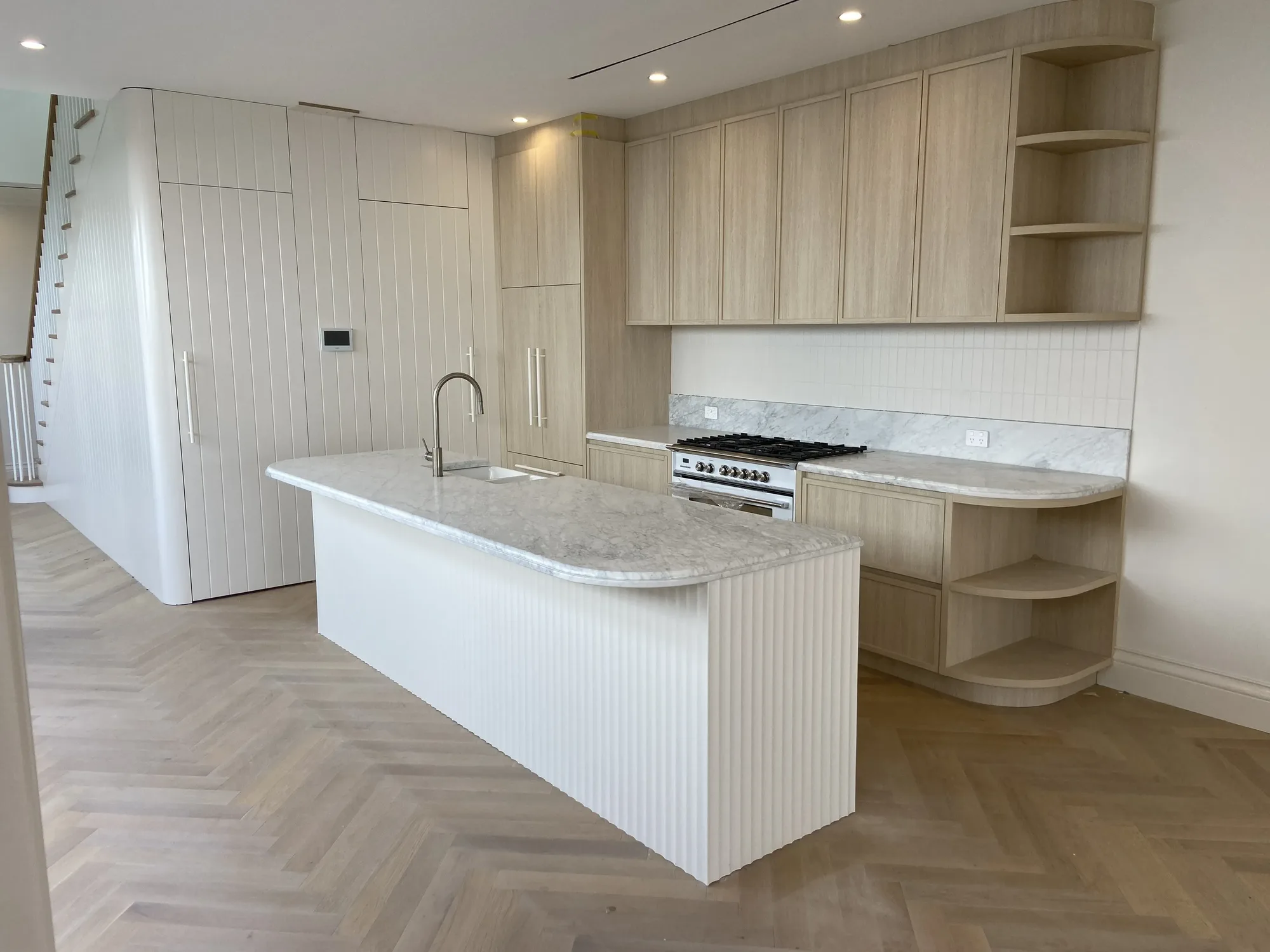 Chic apartment kitchen with pale oak and herringbone floor