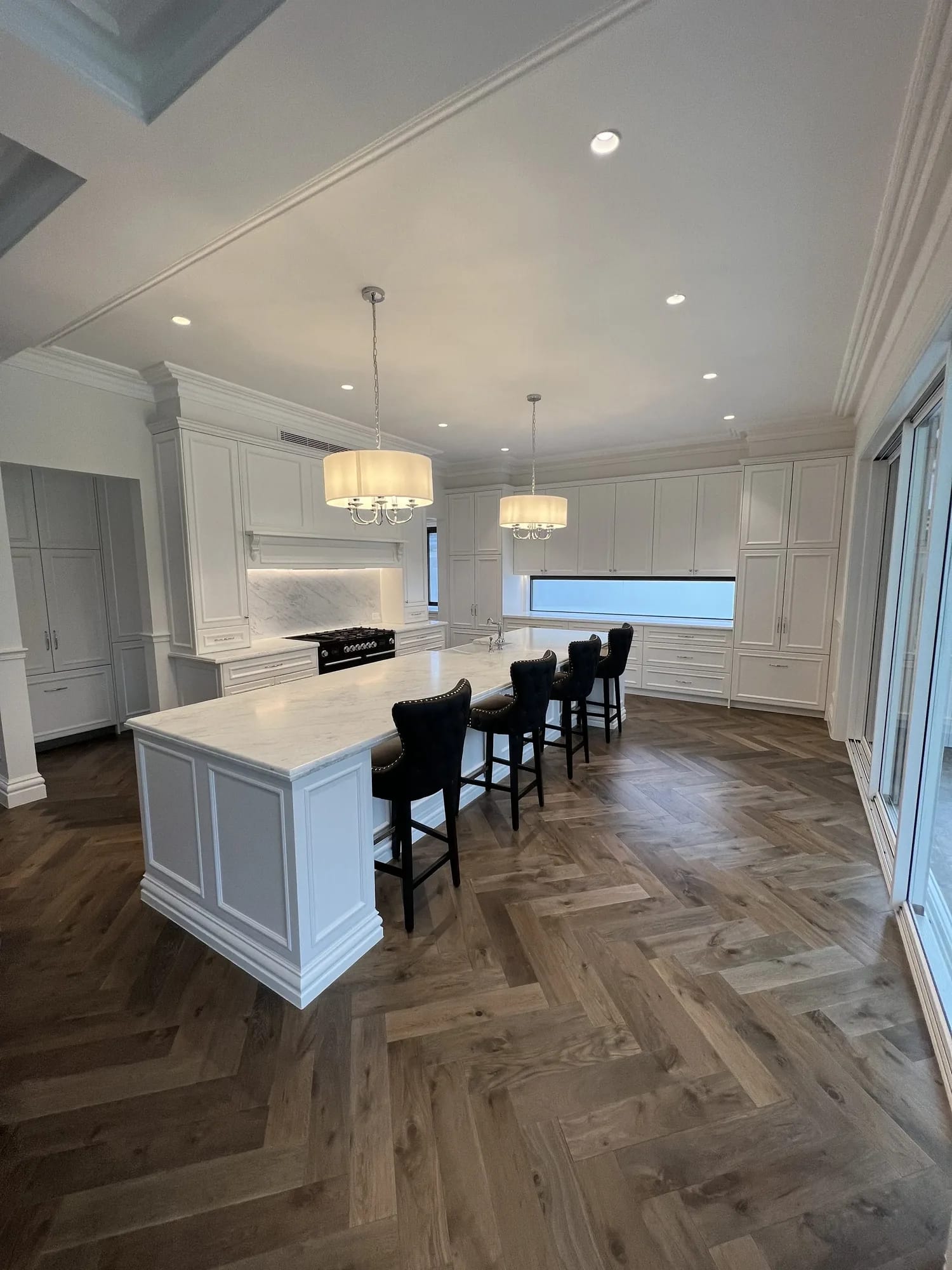 Elegant apartment kitchen with large island and herringbone floor