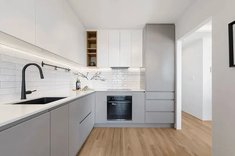 Modern grey and white apartment kitchen with wood flooring