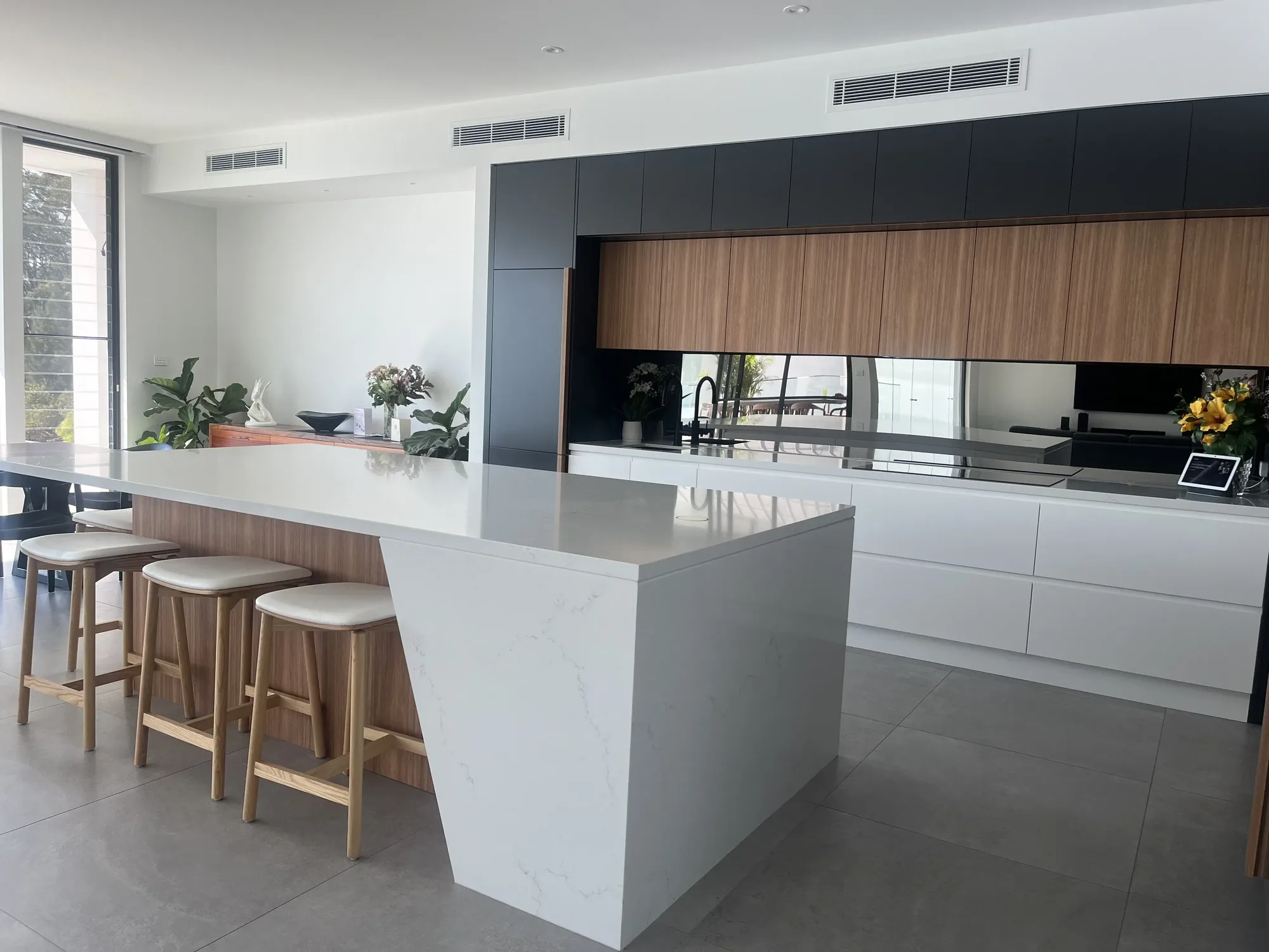 Sleek renovated apartment kitchen in Sydney with marble waterfall island