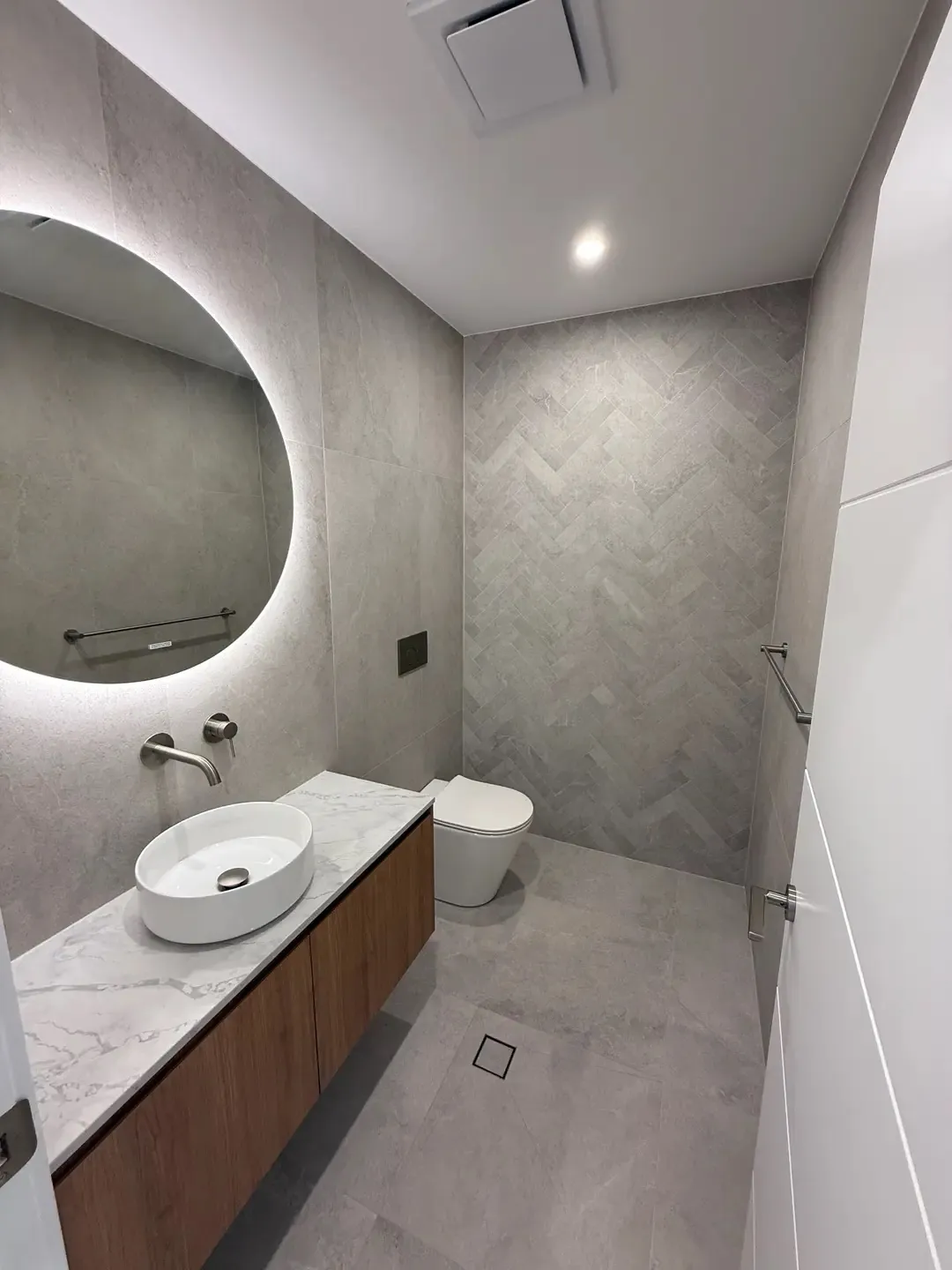 Small bathroom with herringbone feature wall maximising visual space