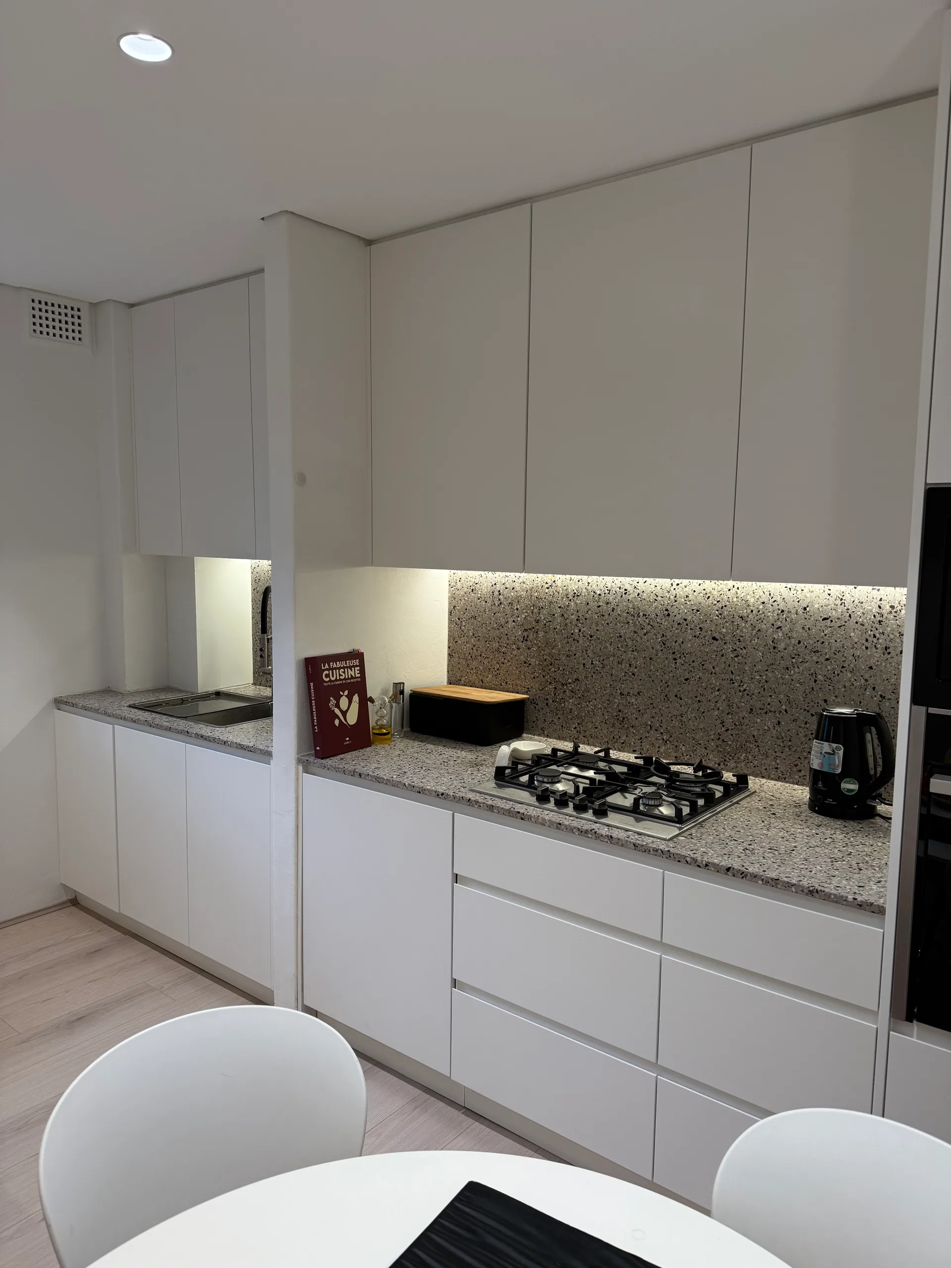 Gas cooktop set into a terrazzo-look stone benchtop in a Bondi apartment kitchen