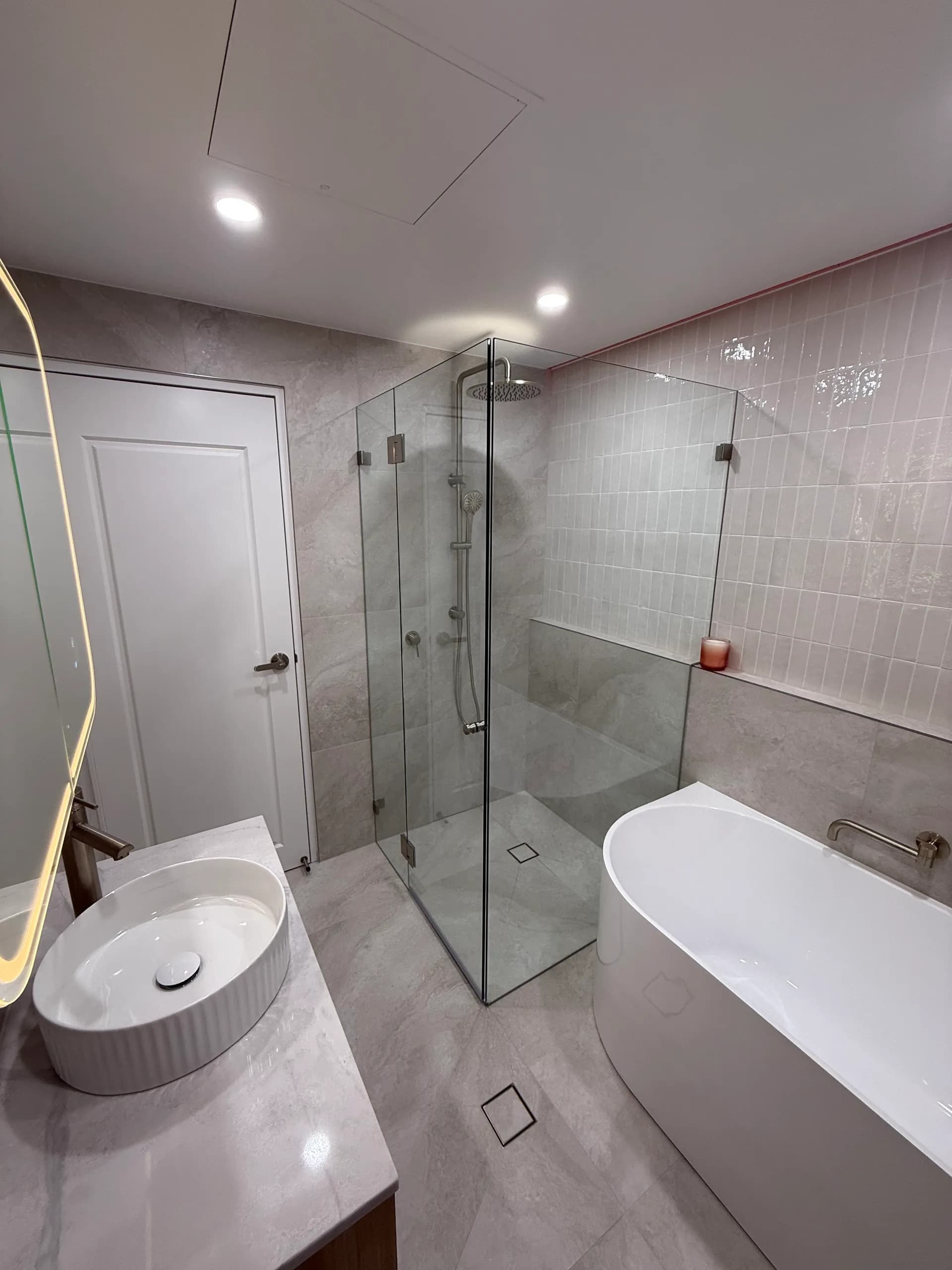 Renovated apartment bathroom with a shower over bath
