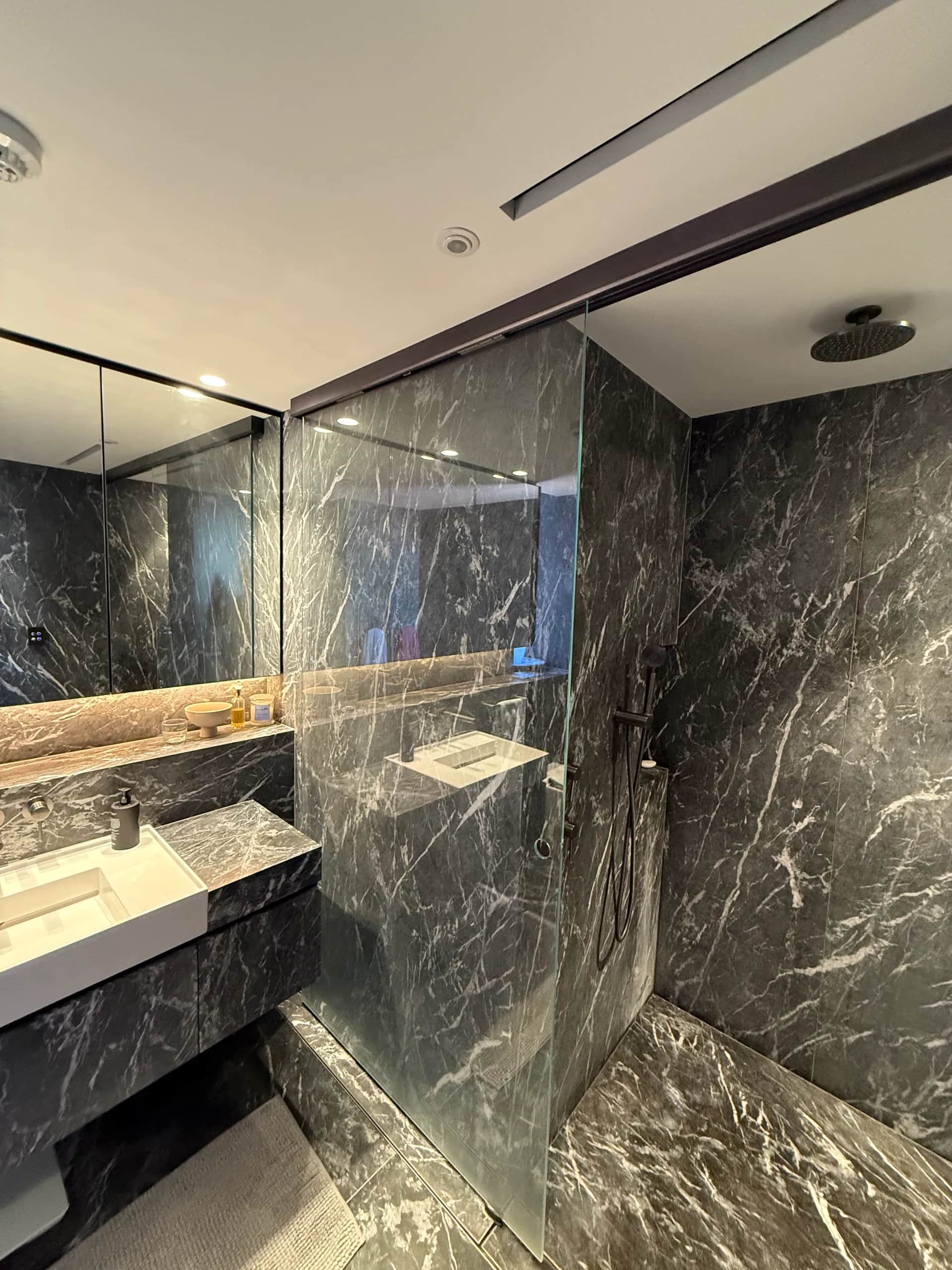 Luxury apartment bathroom renovation in Sydney with marble tiling and frameless shower