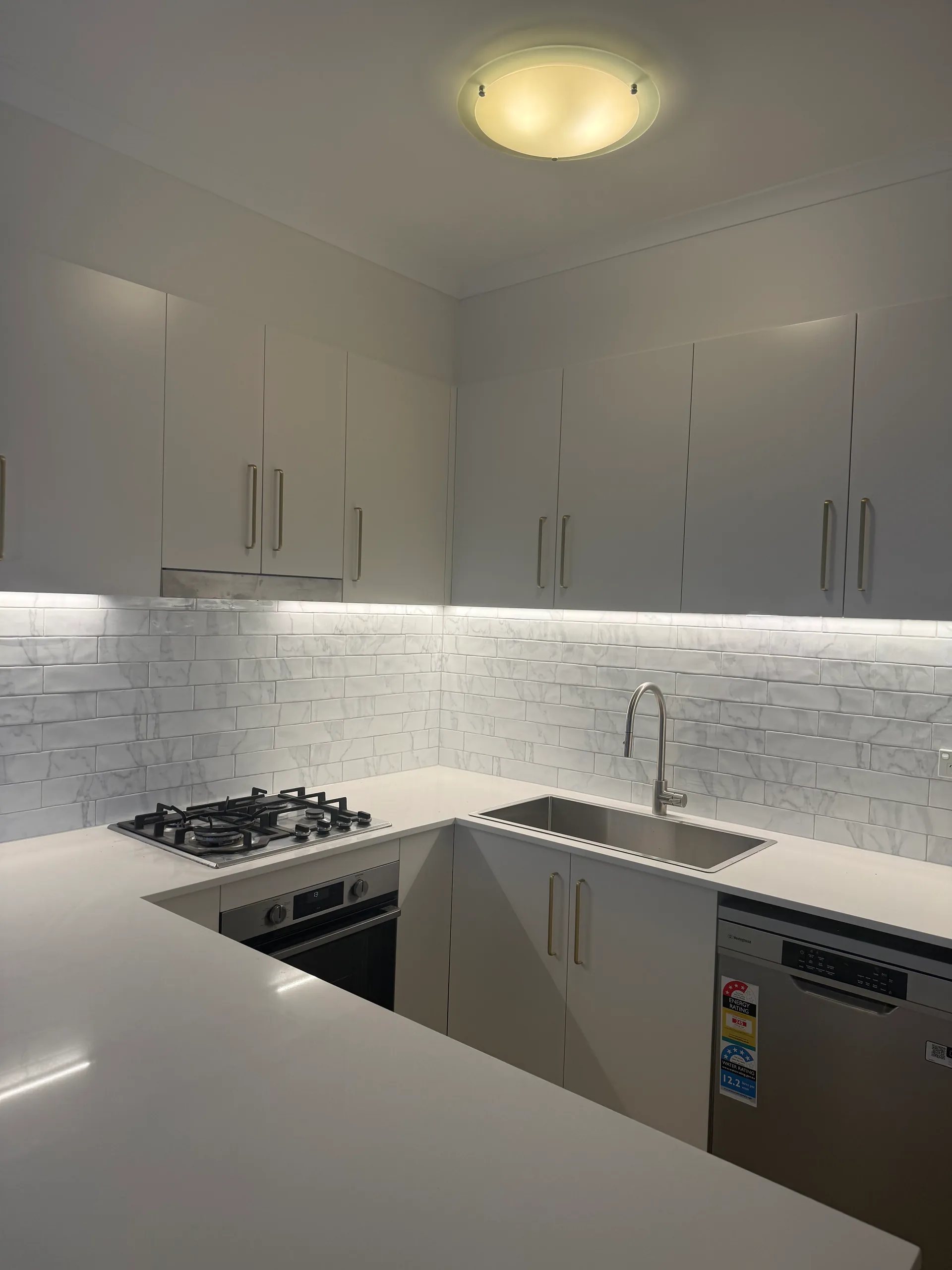 Kitchen cooktop area with tile splashback