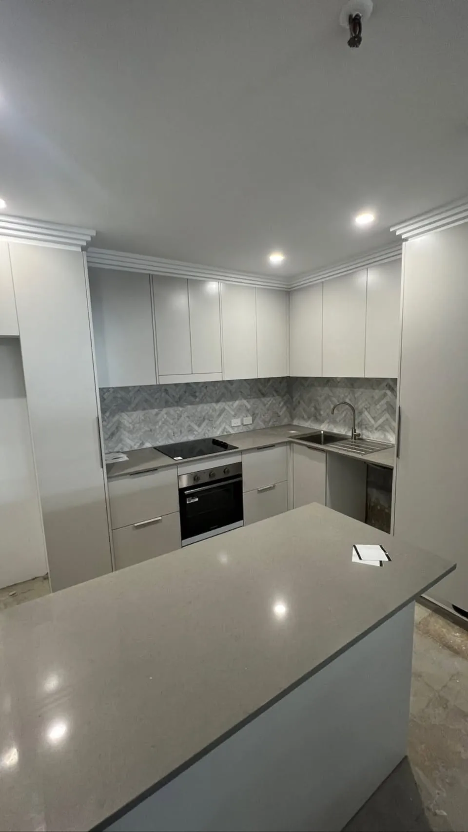 Kitchen with white chevron splashback and dark cabinetry