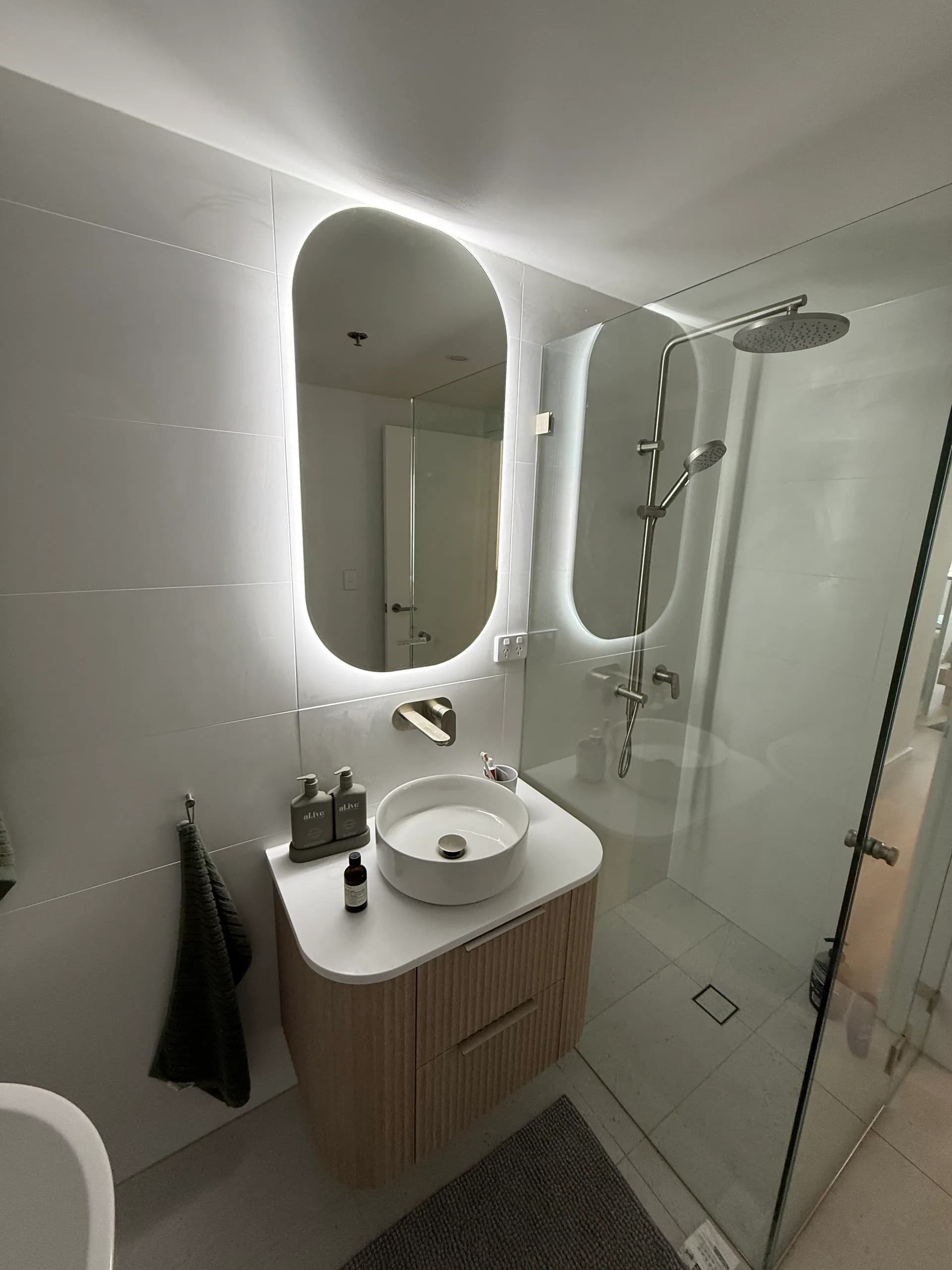 Renovated apartment bathroom with an oval LED mirror