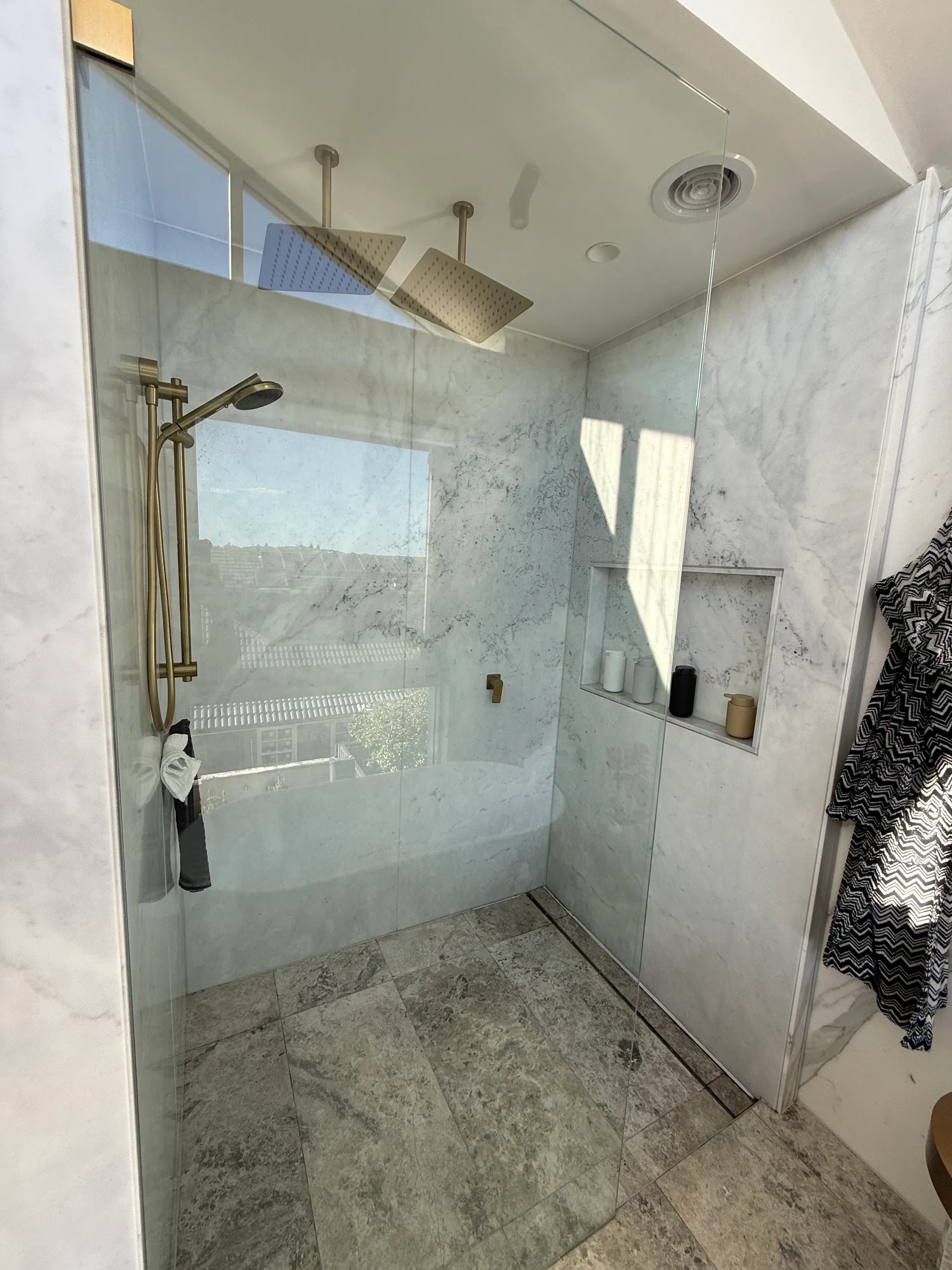 Renovated Vaucluse bathroom with dual rain shower heads and marble walls