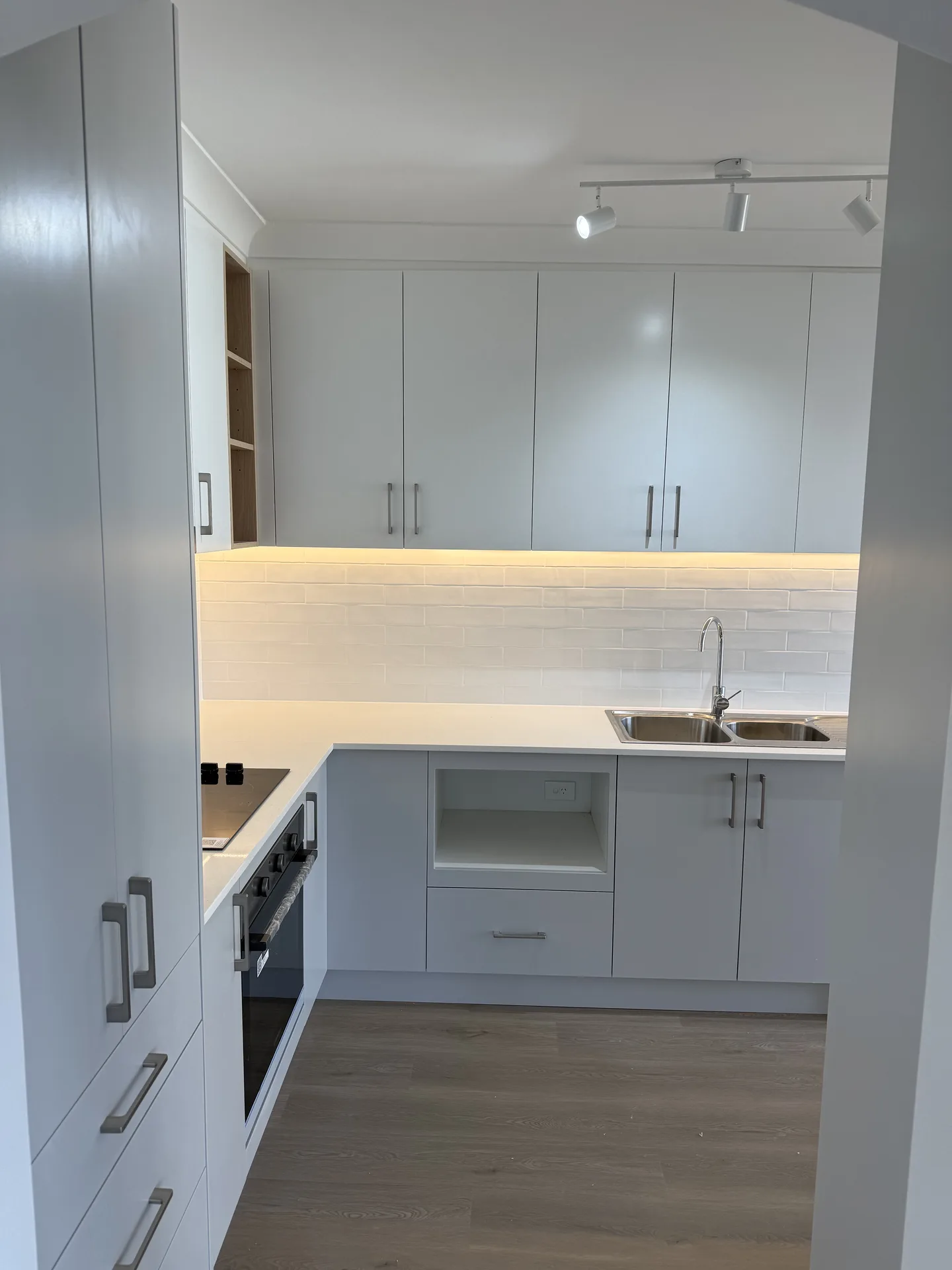 Kitchen seen through the doorway with cabinetry carried up to the ceiling