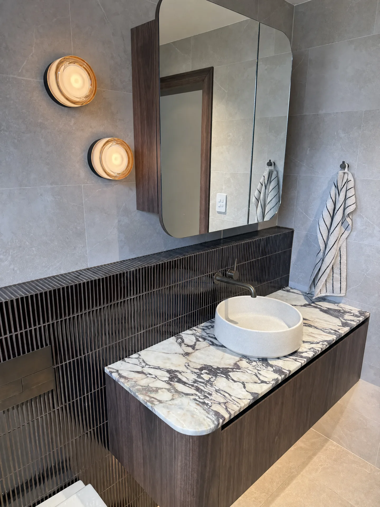 Renovated bathroom in a Bondi Beach apartment, with a floating walnut vanity and a veined marble benchtop