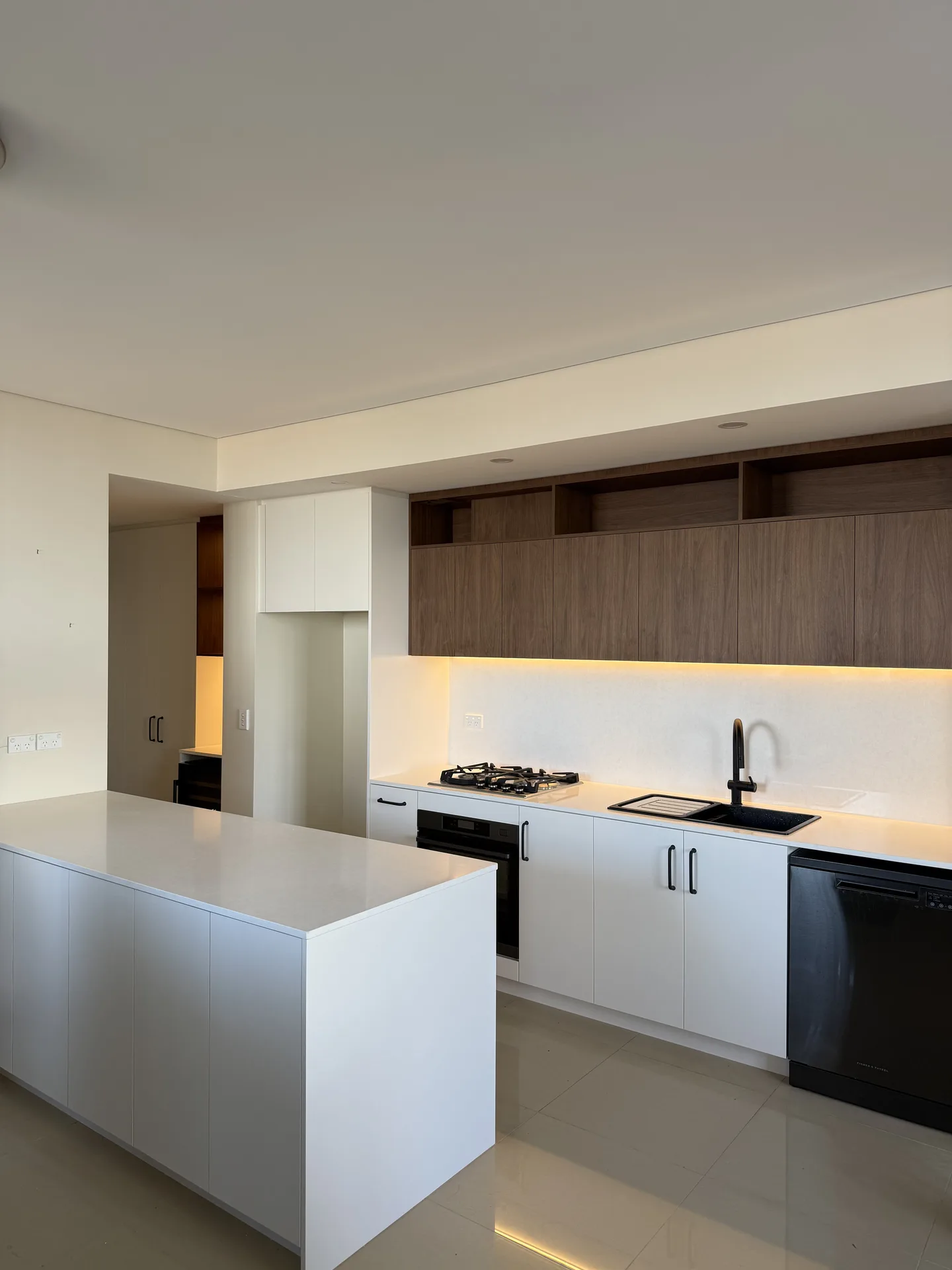 Kitchen viewed across the island, timber overheads running up to the bulkhead