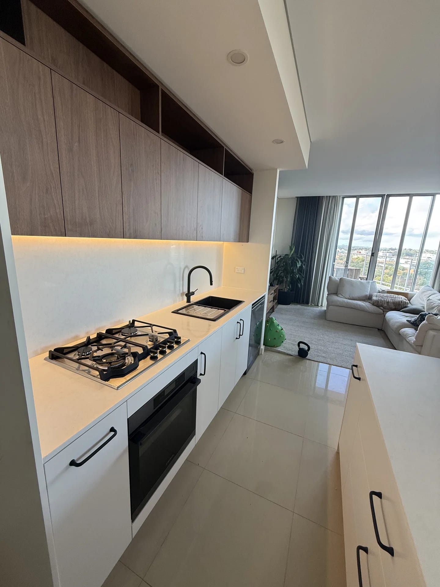 Kitchen open to the living room with full-height glazing and a suburban outlook
