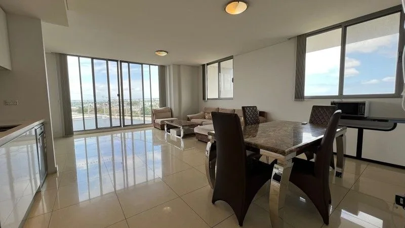 Open-plan living and dining with glossy cream floor tile and full-height glazing
