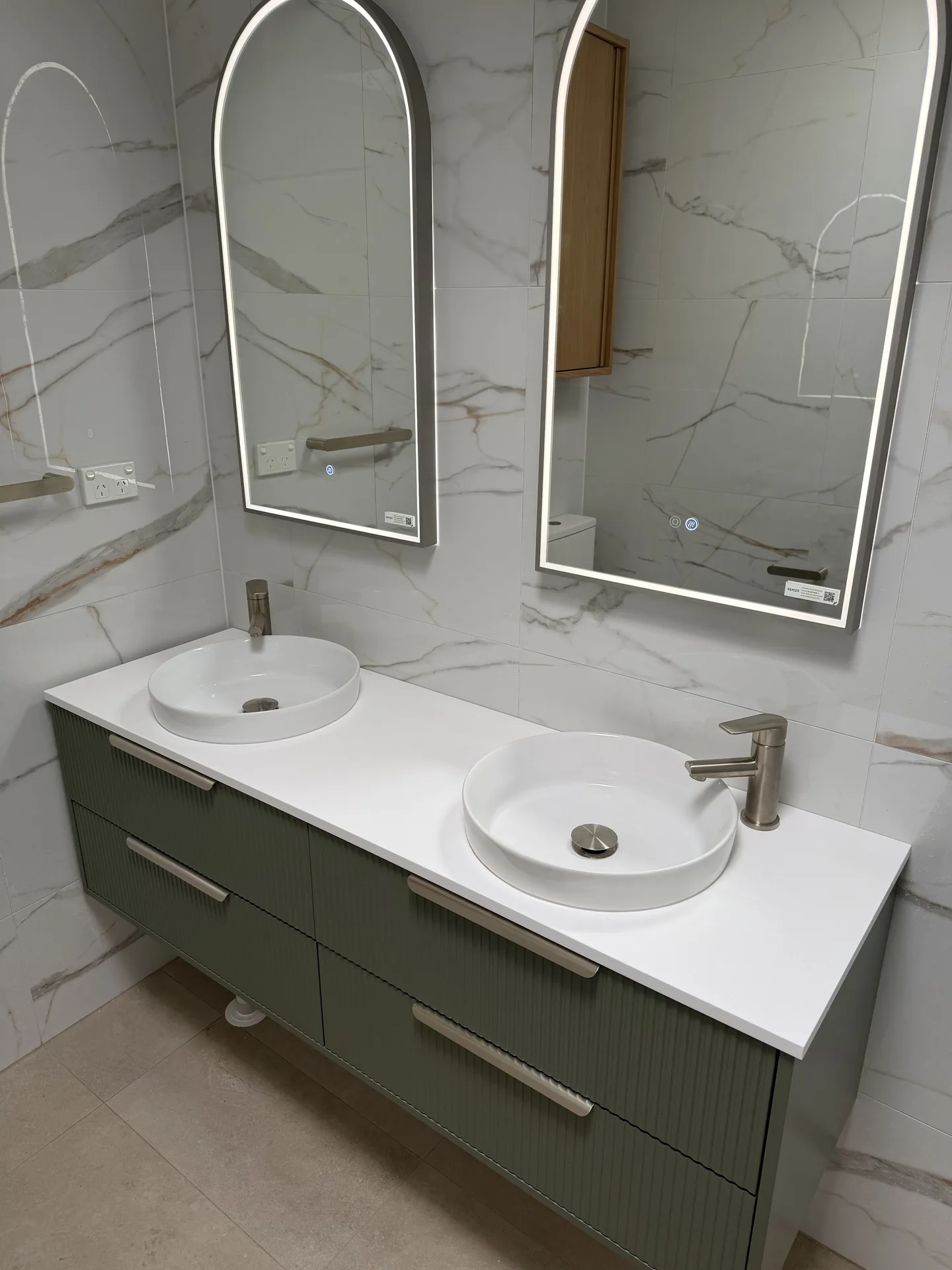 Olive fluted vanity with two round vessel basins on a white stone-look top