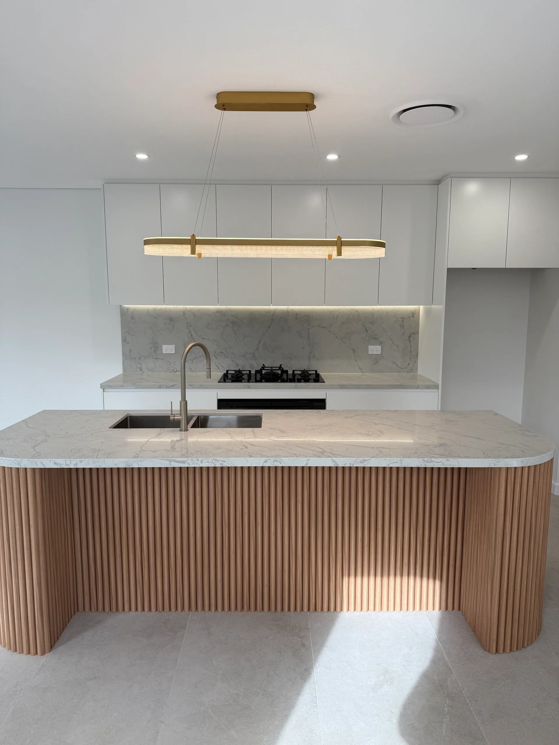 Renovated kitchen with a fluted timber island and marble benchtop