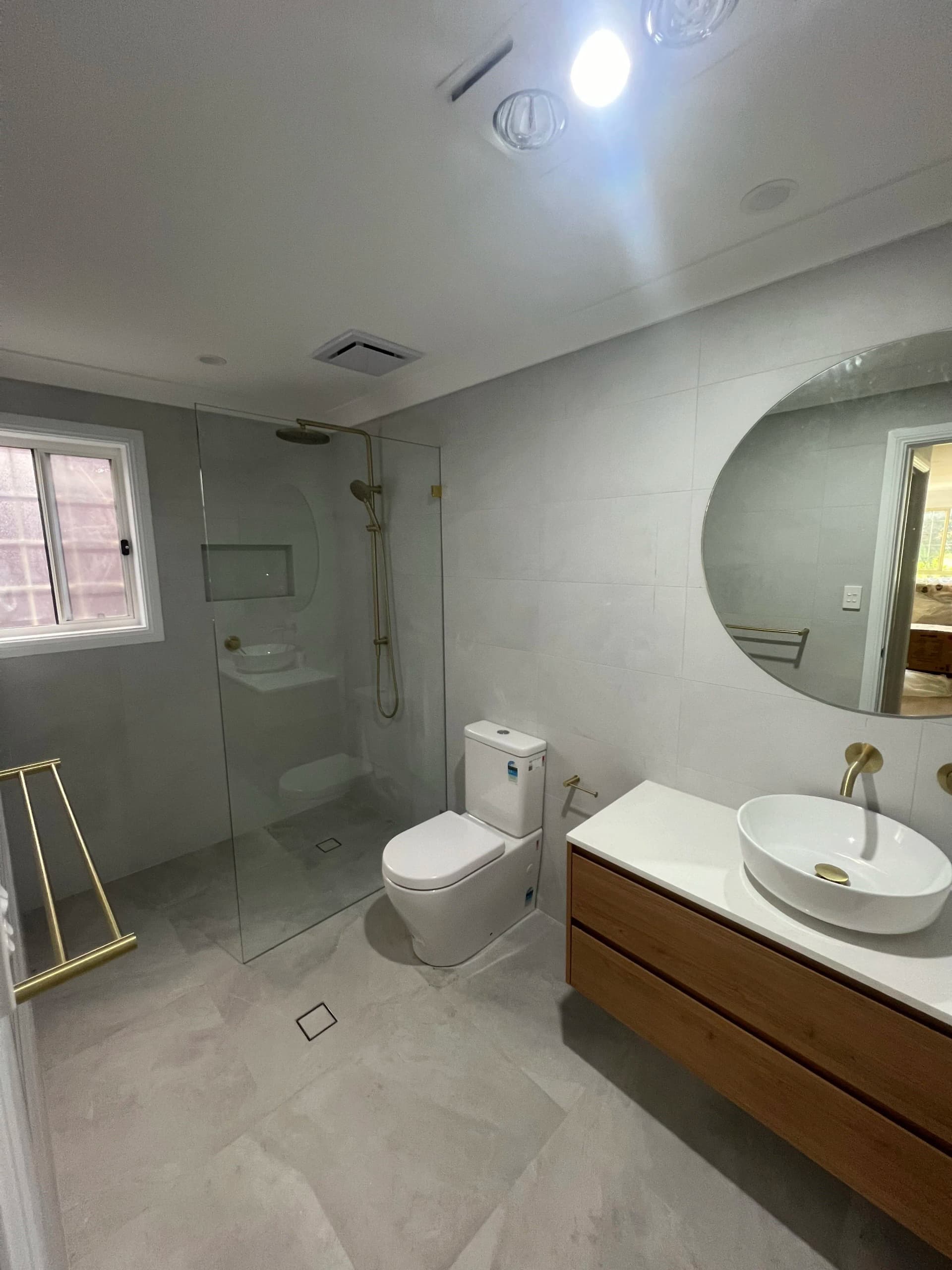 Renovated North Strathfield bathroom with a floating timber vanity and brushed brass fixtures