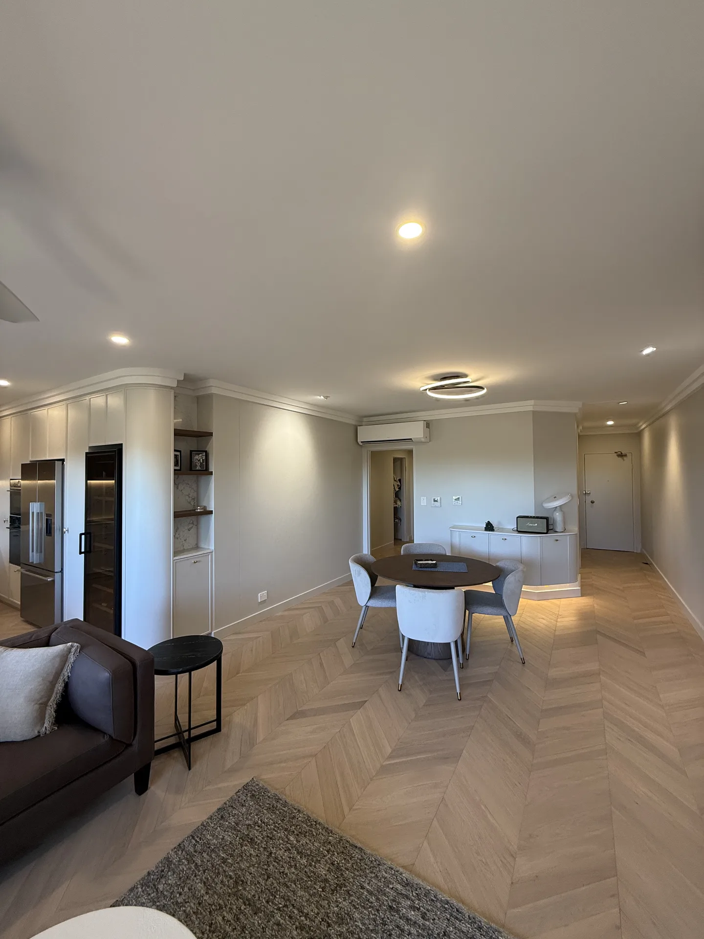 Completed North Sydney apartment renovation with chevron oak-look flooring through the living and dining areas