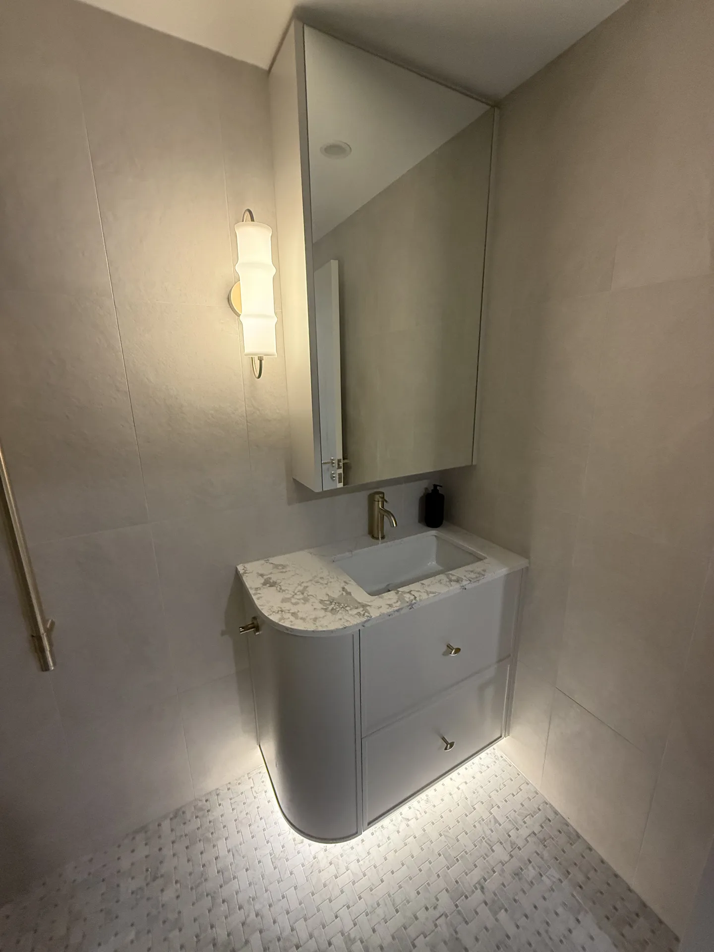 Second bathroom vanity with a curved end, stone top and brushed brass tapware