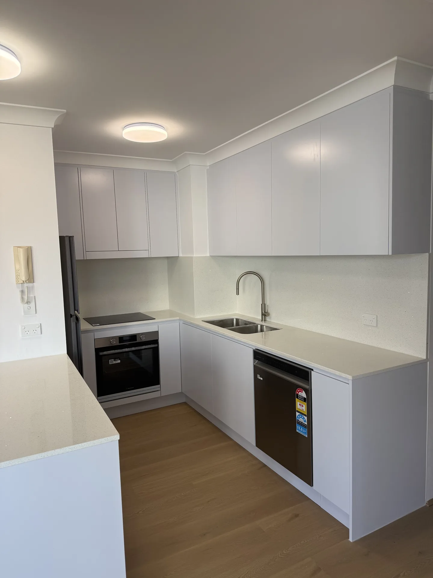 Kitchen bench run with flush cooktop, under-bench oven, sink and dishwasher