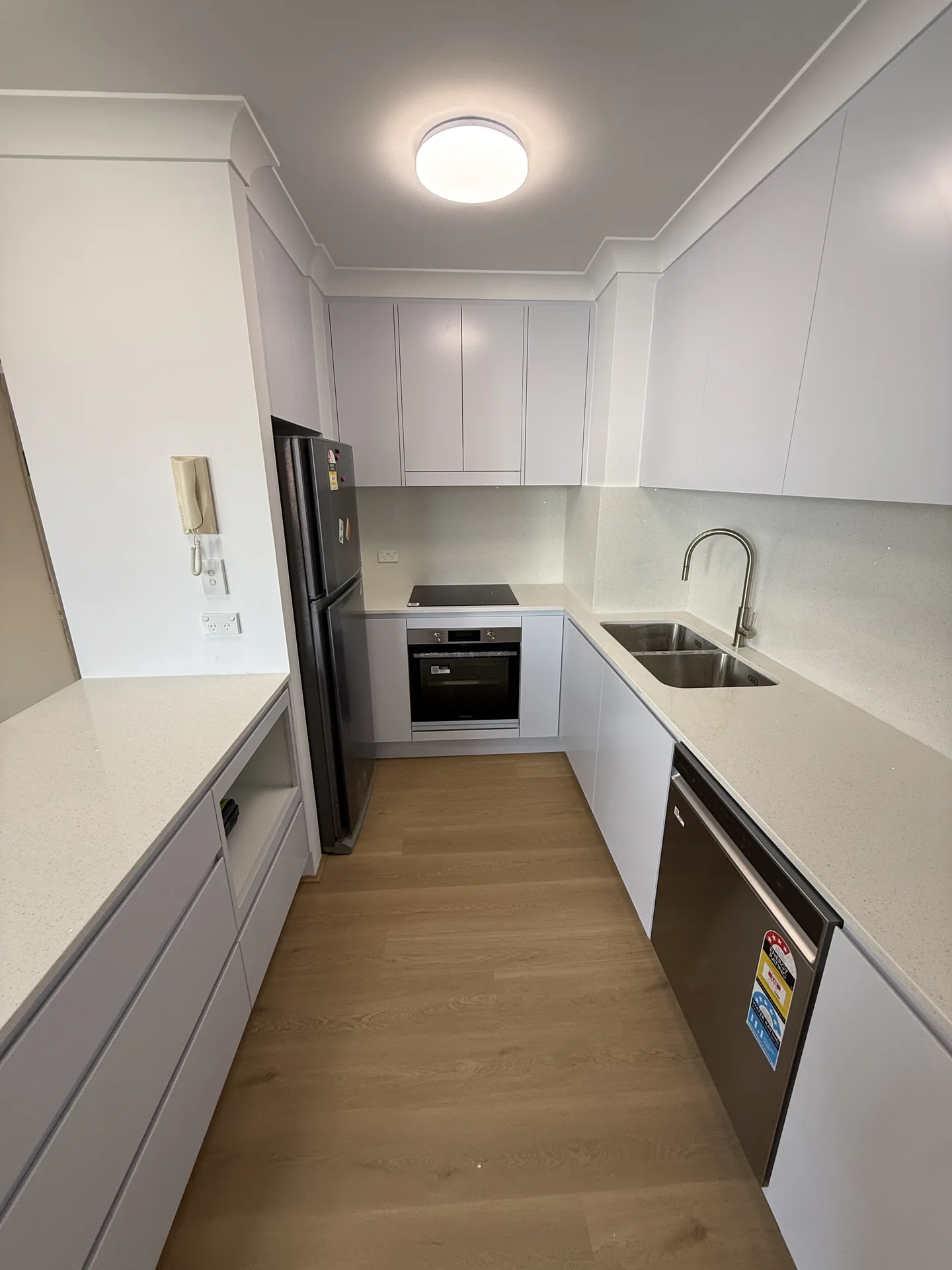 Looking through the U-shaped kitchen towards the cooktop and oven wall