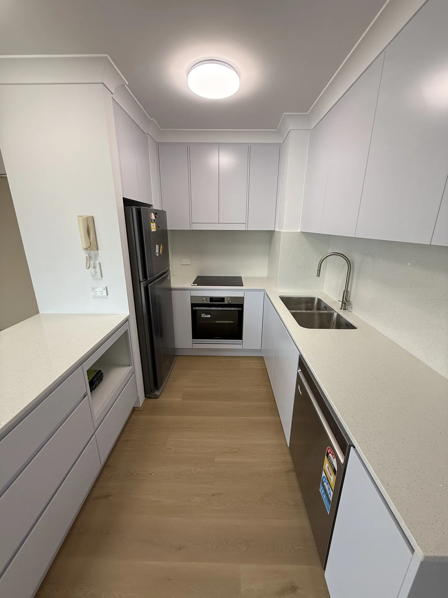 Kitchen drawers and open shelf niche below the peninsula bench