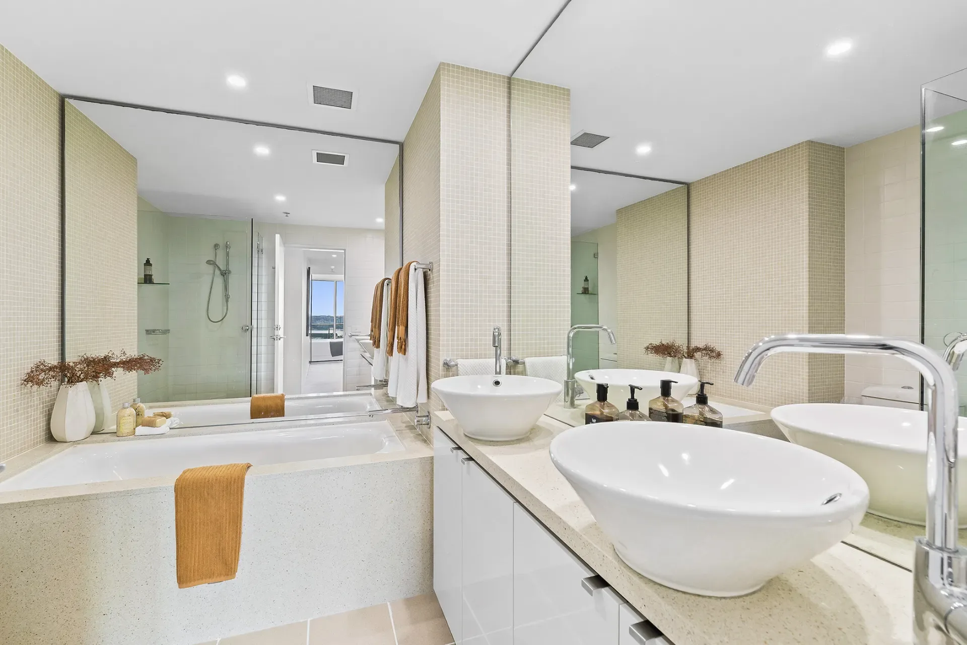 Original cream tiled bathroom with twin white vessel basins and an inset bath