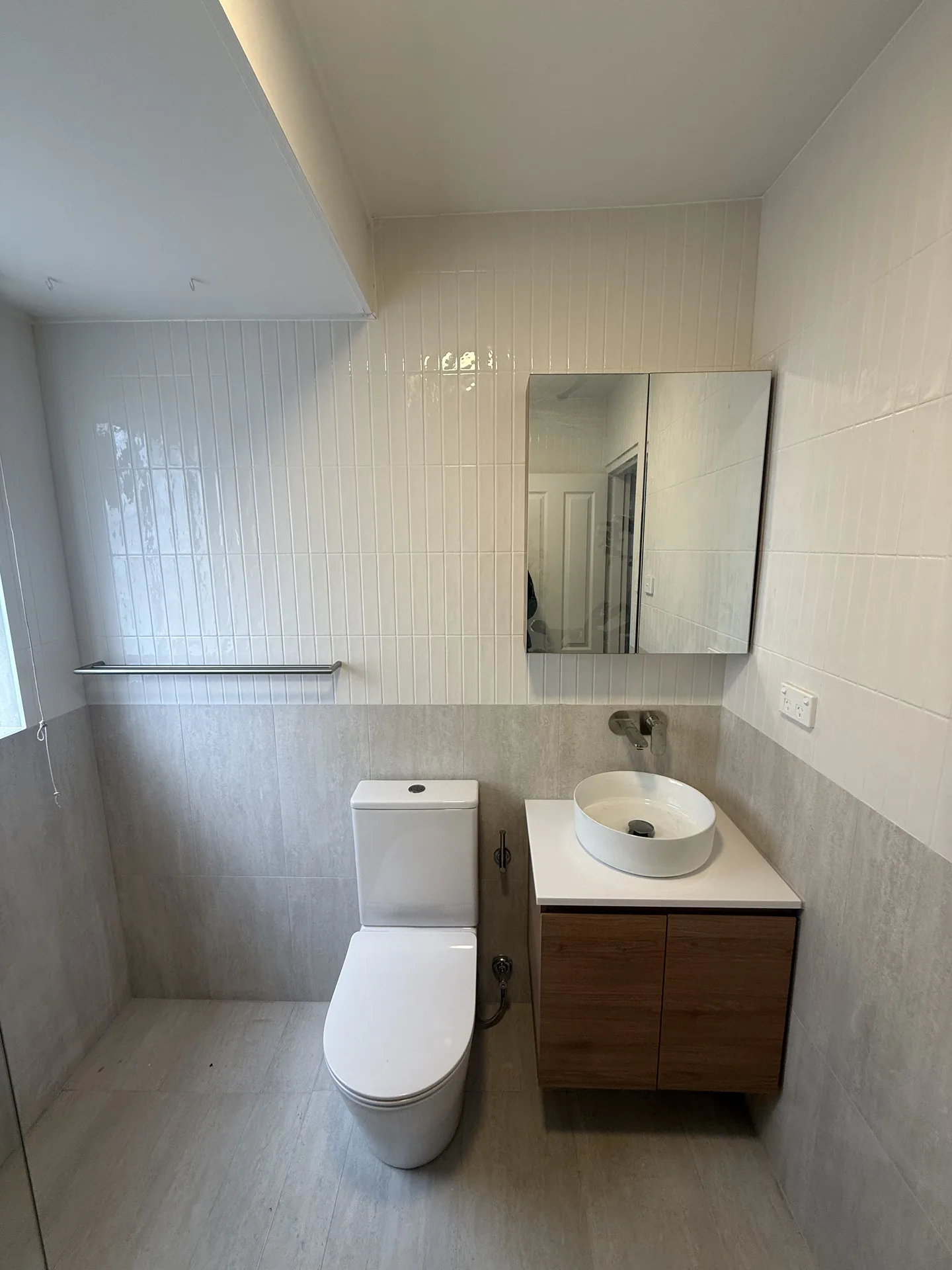 Wall-hung timber-look vanity with oval vessel basin, mirrored cabinet and back-to-wall toilet
