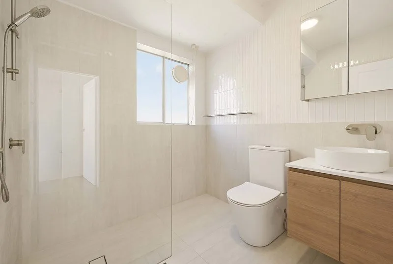 Compact bathroom with step-free walk-in shower, wall-hung vanity and mirrored cabinet