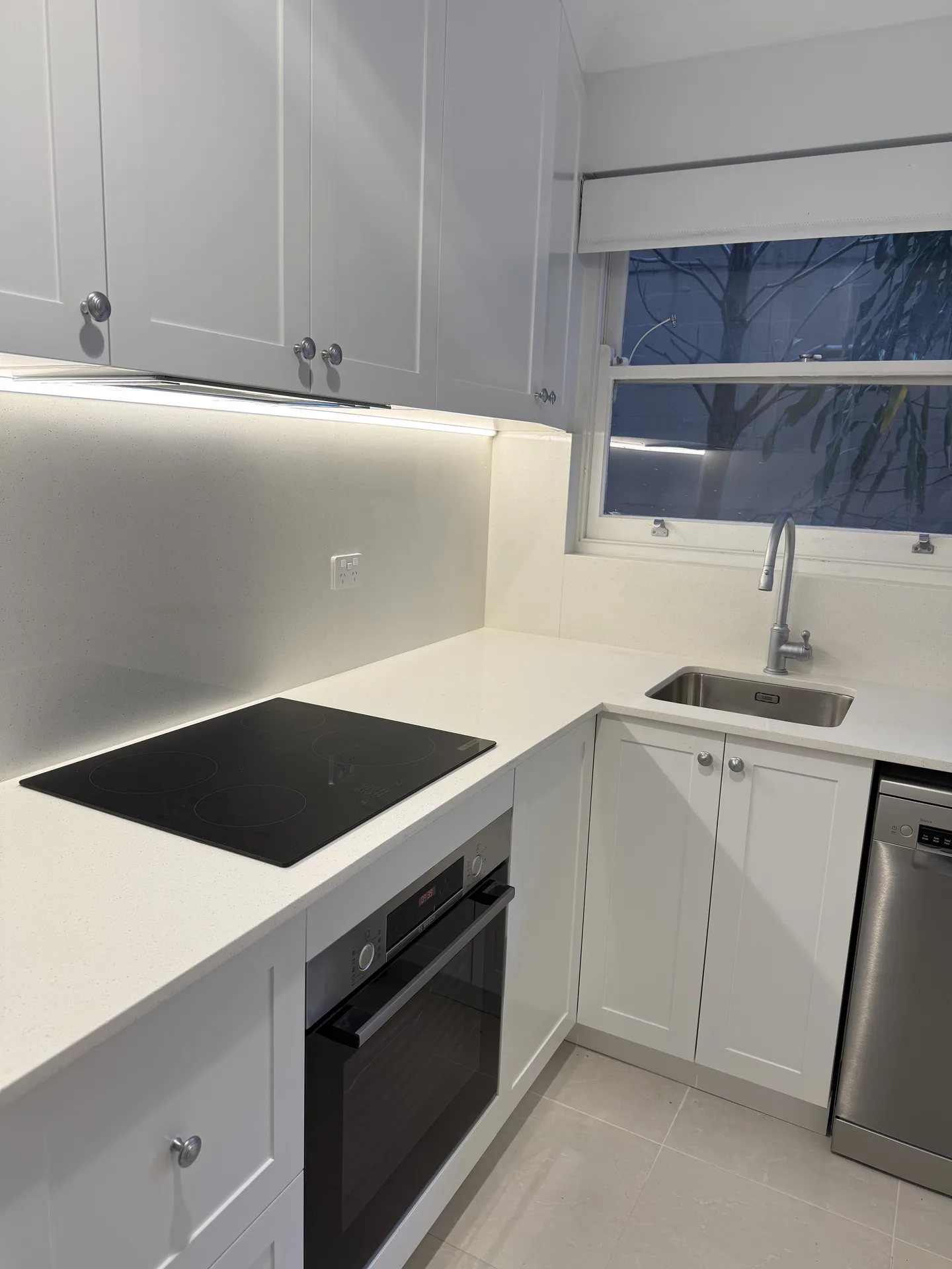 Induction cooktop over an under-bench oven in a renovated Ryde apartment kitchen