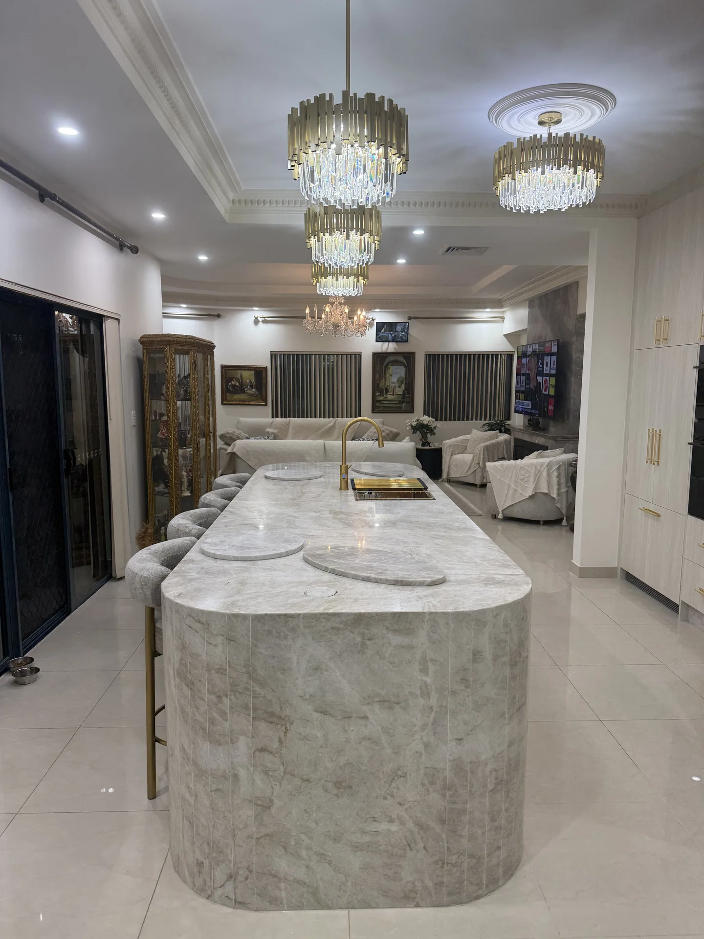 Rounded end of the stone island with vertical fluting, open to the living room behind