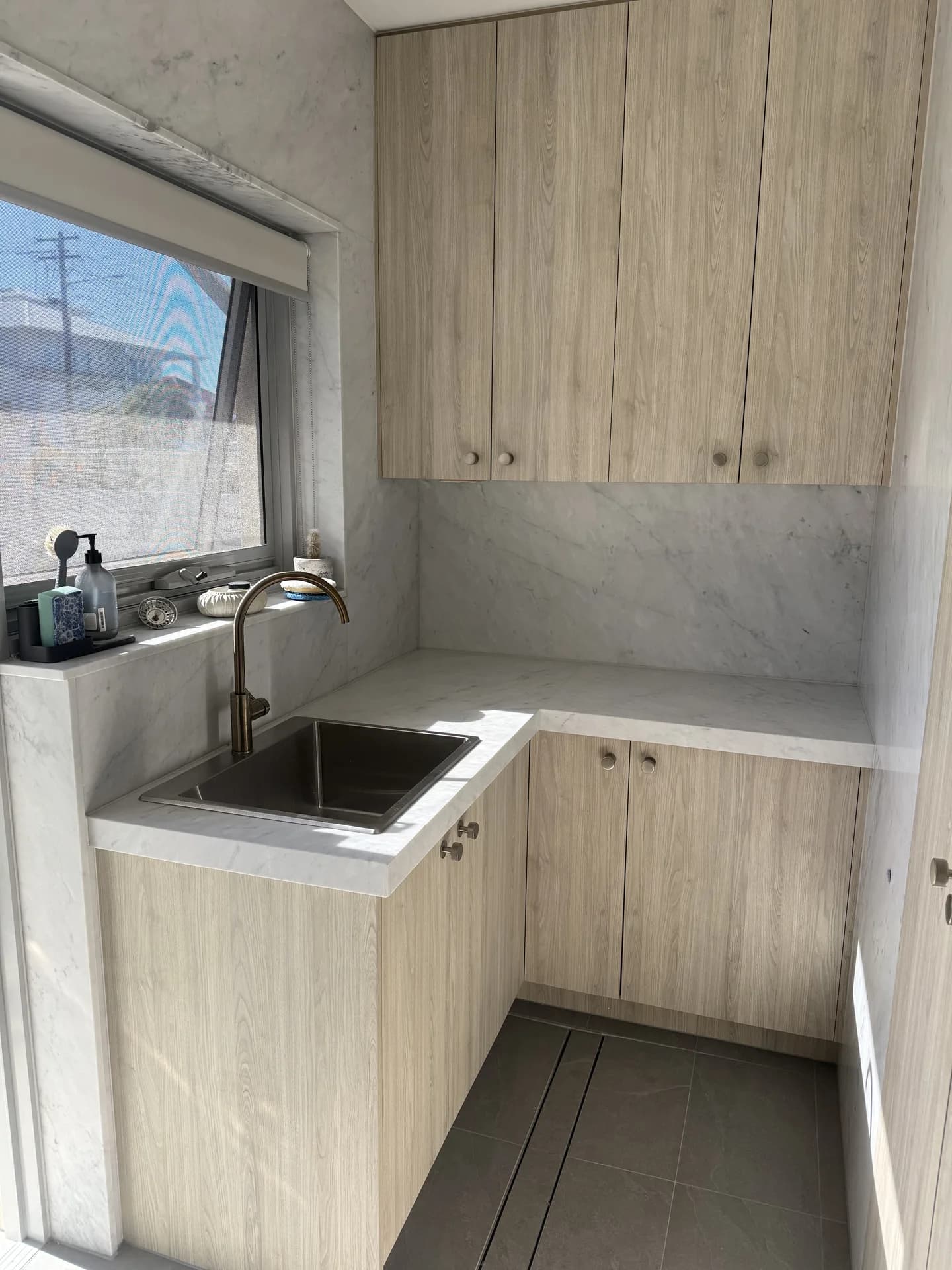 Renovated Vaucluse laundry with oak cabinetry, a marble benchtop and an undermount sink