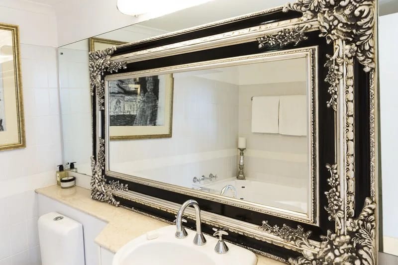 Original second bathroom vanity with an ornate framed mirror and chrome tapware