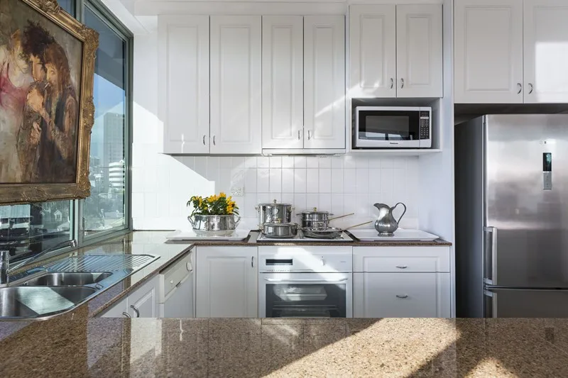Original white shaker kitchen with speckled granite benchtop and white tile splashback